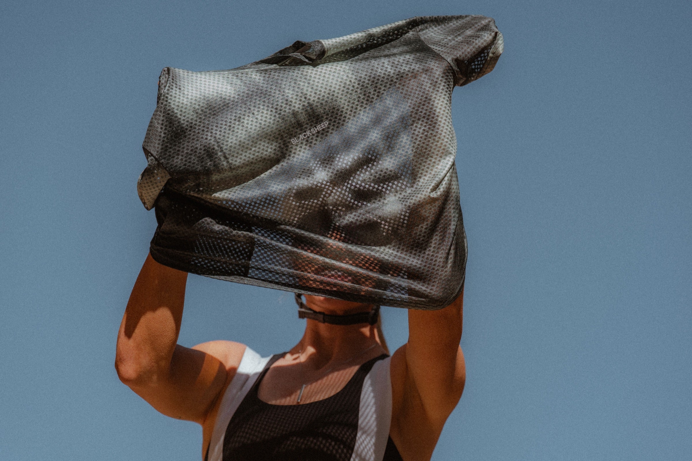 The Enduro Mesh Tee held up against the sky